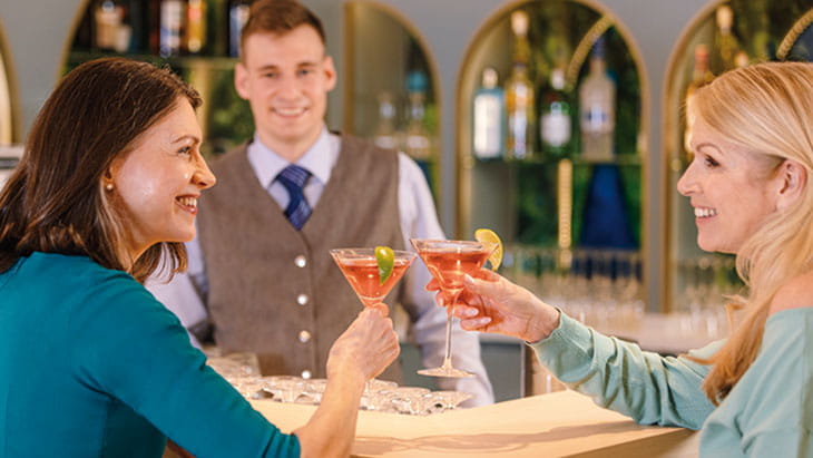 Two friends enjoying drinks in the Belvedere Lounge on Spirit of the Danube